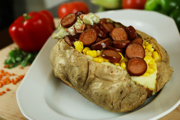 Kumpir - Turkish baked potato with butter, cheese, corn, beef sausage, vegetable salad and spices. This kumpir is traditional turkish food isolated on white background