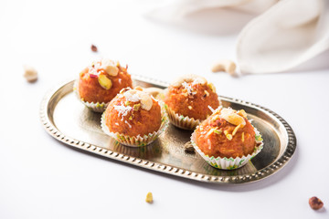 Carrot Halwa Laddu or sweet balls,  served in a plate with dry fruits toppings. selective focus