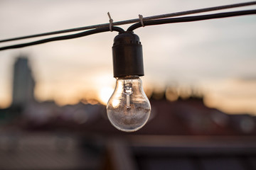 Obraz premium Vintage beautiful lamps on the street at sunset. City decoration. Chain of lamps on the wire. Belarus, Minsk.