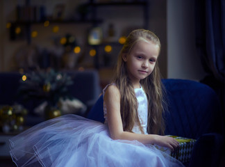 child with Christmas gifts on garland background
