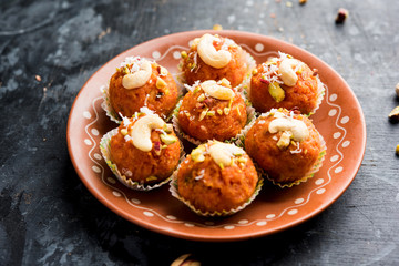 Carrot Halwa Laddu or sweet balls,  served in a plate with dry fruits toppings. selective focus