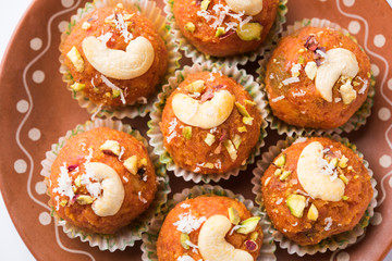 Carrot Halwa Laddu or sweet balls,  served in a plate with dry fruits toppings. selective focus