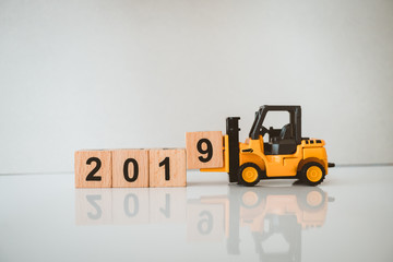 Miniature forklift lift up year 2019 wooden block using as business and industry concept