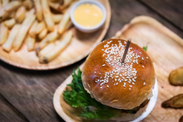 Hamburger and French fries on the wooden tray