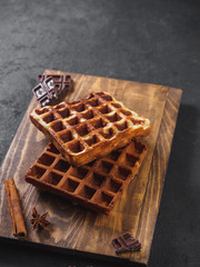 Belgian waffles with chocolate on wooden board