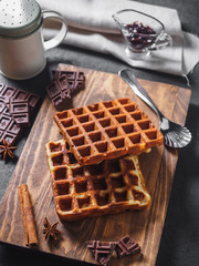Belgian waffles with chocolate on wooden board