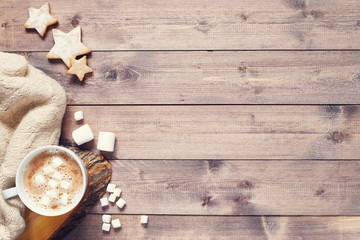 Wooden background with cup of cocoa with marshmallow