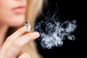 Fototapeta premium Portrait of the young elegant girl smoking cigarette isolated