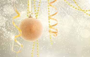 Hanging golden christmas ball with garlands on silver bokeh background