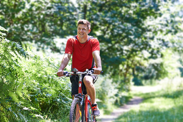 Obraz premium Active Man Cycling Along Path In Countryside