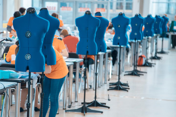 Blurred background with women are engaged in tailoring of tights in a factory