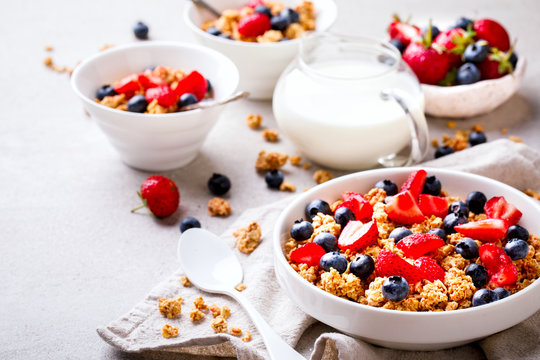 Granola Cereal bar with Strawberries and blueberries  and Milk on the Gray Background. Muesli with  berries Breakfast. Healthy Food sweet dessert snack.Vegetarian food. 