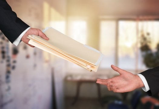 Hands of businessmen holding documents on background