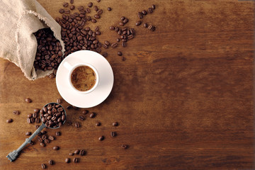 Kaffeetasse und Kaffeebohnen auf Holzhintergrund. Ansicht von oben.