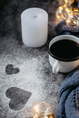  Cup of coffee , candle, notebook, pen and warm woolen sweater , decorated with led lights on gray table.Winter  concept. Flat lay, top view. Valentines day.