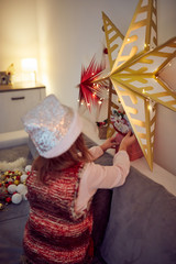 Child girl preparing shiny decoration for Christmas / New Year's eve.