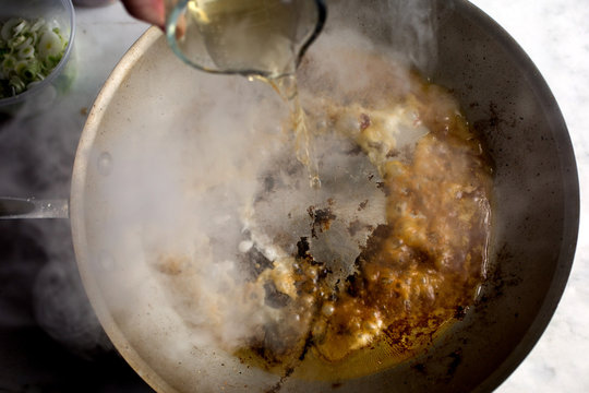 Close up of oil pouring in frying pan 