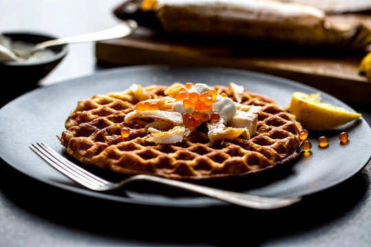 Close up of potato waffles with smoked trout served on plate