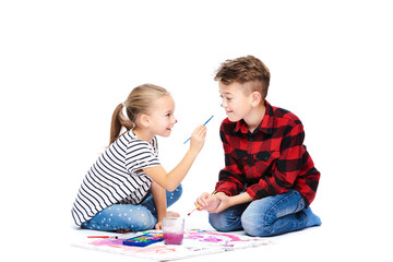 Brother and sister having fun painting with watercolors. Happy creative children at art class. Art therapy concept on white background.