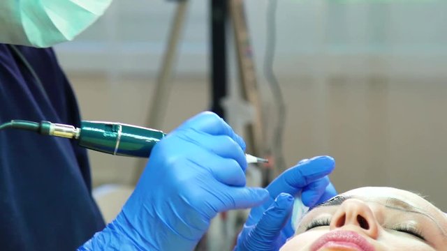 Beautician doing eyebrow micropigmentation or microblading. Beauty Procedure