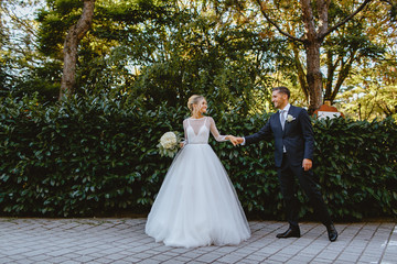 Bride and groom walk through the park in the city of Ravenna.