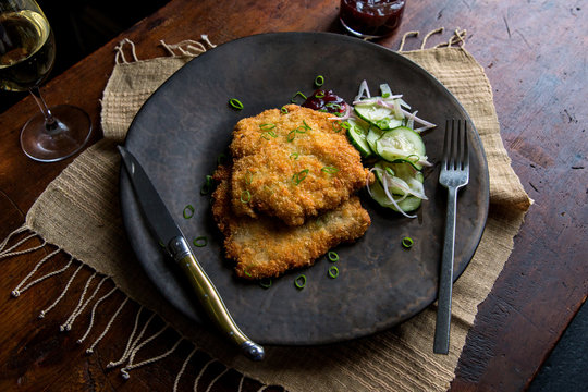 Pork schnitzel served on plate with pickled veggies
