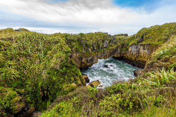 Sea and natural layered rock formations from erosion. Pancake Rocks and Blowholes, Paparoa National Park, West Coast, near Hokitika, New Zealand.