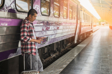 Obraz premium Traveler with baggage and digital tablet in train station. Travel concept.
