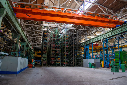 The interior of a large warehouse of heavy iron products and metal goods with pallet storage shelves at a production forge plant. Rows of shelves in commercial factory Industrial plant in Belarus