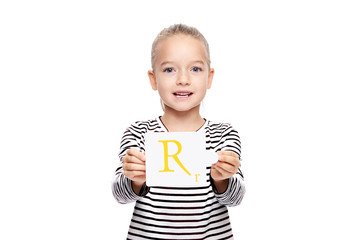 Young girl holding a card with letter R. Speech therapy concept on white background. Correct pronounciation and articulation at preschool age.