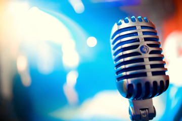 Fototapeta na wymiar Retro microphone against blur colorful light restaurant background