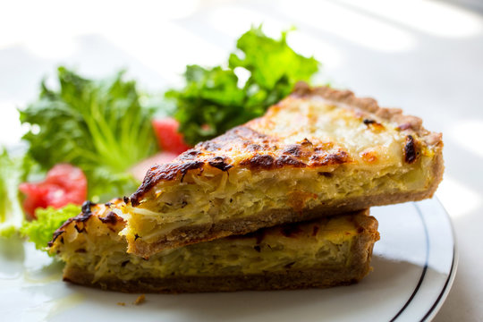 Close Up Of Cabbage And Spring Onion Quiche Slices Served On Plate