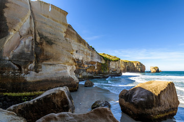 Fototapeta na wymiar Sculpted cliffs, eroded rock formations and rough sea waves at Tunnel Beach, Otago region, South Island, New Zealand
