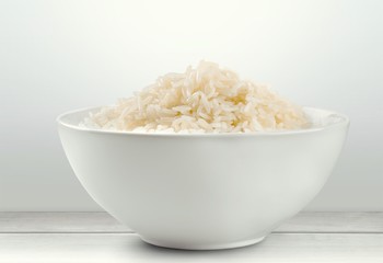Plain rice in ceramic bowl on background
