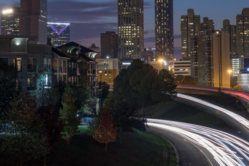 Urban city skyline at night with cars going by.