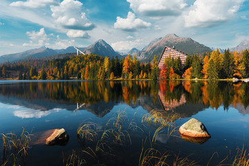 Fototapeta Picturesque autumn view of lake Strbske pleso in High Tatras National Park, Slovakia. Clear water with reflections of orange larch and high mountains on background. Landscape photography obraz