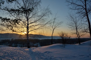 winter landscape at the sunset with trees and frozen river
