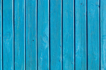 Aqua colored wooden gate with iron stripes