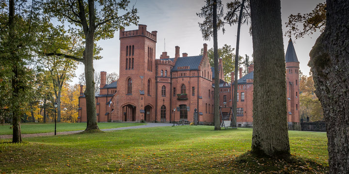 Old red brick manor house in the style of English castles. Sangaste Castle, backyard. Estonia, Baltic. Panoramic view.