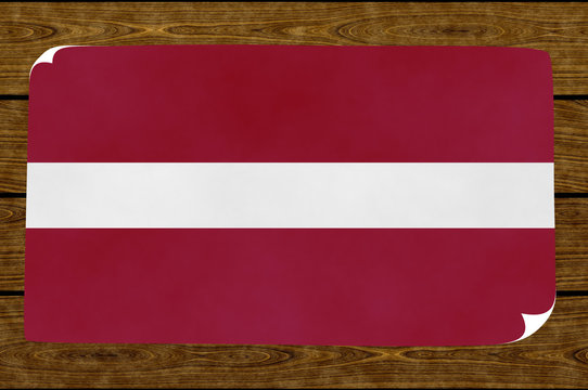 Illustration of a  Latvian flag painted on the papier pasted on the woody wall