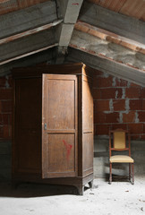 old wooden wardrobe and a chair in the attic