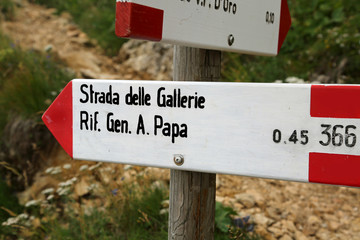 trail marker with text of italian location in mountains