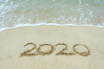 Year 2020 number on a sand beach with waves - New Year concept