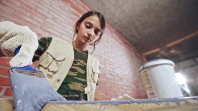 Girl coating wood with paint