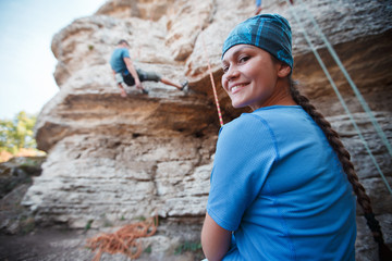 Photo of smiling woman rock climber on background of cliff