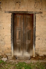 Fototapeta na wymiar puerta de madera pared de adobe