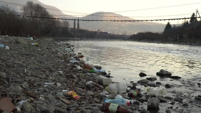 Rubbish on the river. Garbage in a mountain river. Environmental pollution. Pollution of nature. Ecological catastrophy. Non-degradable plastic.