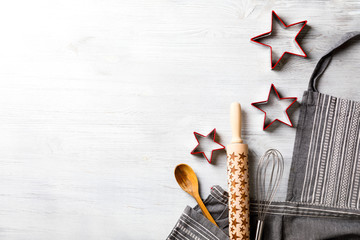Kitchen apron on Holiday Background Concept of Christmas and New Year. Festive  Baking. Poster design, rolling and whisk, a wooden spoon and cookie cutters and gingerbread. Copy space for Text.