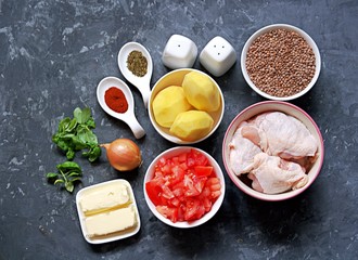 Ingredients for the preparation of chicken stew with lentils, potatoes and tomatoes: Chicken pieces, lentils, tomatoes, butter, peeled potatoes, onions, fresh basil, spices, salt, pepper. Top view.