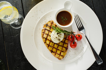 Grilled chicken with sauce and cherry tomatoes.